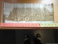 Full view showing the entire panoramic photo with soldiers seated in rows wearing military uniforms, placed next to a measuring tape for scale (approximately 31 inches wide).