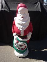 Front view of blow mold Santa showing red suit, white beard, and green sack with toys.