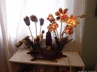 Front view of unique floral lamp made of cow horn, illuminated petals glowing.