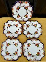 All five square scalloped antique plates with floral Imari pattern arranged close for overview.