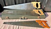 Three musical saws with wooden handles and original black case beneath