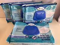 Four sealed packs of Tena ProSkin Classic wipes arranged with the front of packaging visible showing the blue flip-top dispenser and product branding.