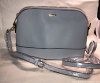 Photo of a new greyish Lovevook purse measuring approximately 11x8 inches with an adjustable shoulder strap.