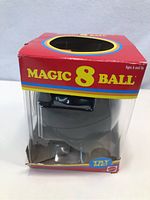 New Magic 8 Ball toy in original red box with dents visible on box corners.