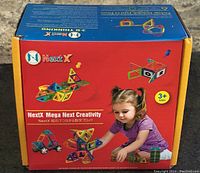 Front side of the NextX Mega Next Creativity magnetic building blocks box showing recommended age and images of models created with the blocks.