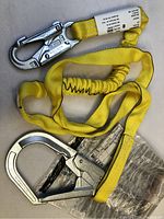 Full view of bright yellow lanyard with metal locking snap hooks at both ends.