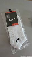 New white Nike socks in original plastic packaging.