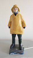 Front view of vintage Old Salt Fisherman door stop showing detailed face, raincoat, gloves, boots, and weighted base.