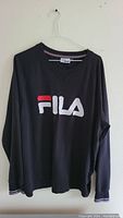 Front view of black Fila sweater with logo and ribbed collar.