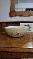 Side profile of the large Pyrex Forest Fancies mixing bowl showing the exterior brown woodland cabin scene.