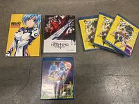 Full lot of anime Blu-ray and DVD discs including Misaki Chronicles, Hellsing Ultimate, four yellow DVD volumes, and Dragon Ball Super Blu-ray.