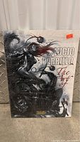 Front cover of Lucio Parrillo The Art of hardcover graphic novel with fantasy artwork of a female character and monochrome background with red accents.