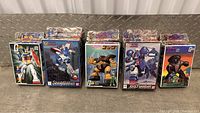 Front view of the five original boxed Gundam model kits arranged side by side, colors and details visible