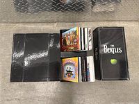 Photo of the CD box set containing multiple Beatles albums, showing the opened box and albums inside.
