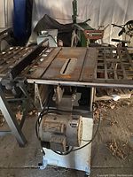 Front view of the table saw showing the metal work surface, side extensions, and motor underneath.