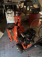 Front-left view of entire snowblower in garage