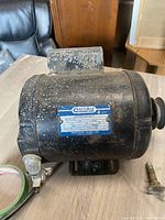 Side view of the black cylindrical Craftsman capacitor start motor showing label and wiring connections.