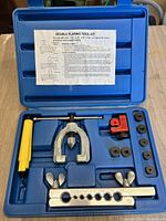 Opened blue plastic case with flaring tool kit items arranged inside including yoke, bar, cutters, and adapters.
