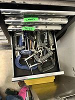 Drawer open showing multiple metal C clamps inside.