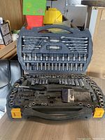 Open view of socket set in plastic case showing many chrome sockets, wrenches, and bits arranged in molded slots.