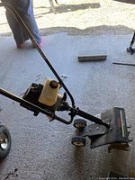 Left-side view showing handles, engine, fuel tank and tines