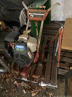 Front angle view of red and white tiller showing engine and tines