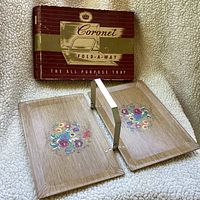 Foldable tray open showing two halves with floral design on wood grain finish next to original vintage Coronet box.