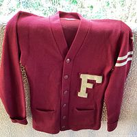 Front view of the maroon vintage letterman's sweater showing large cream 'F' on left chest and two cream stripes on left sleeve with button closure and pockets.