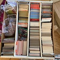 Full view of the box containing hundreds of baseball cards organized in rows with plastic sleeves on some.