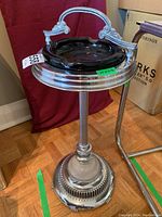 Full view of the vintage ashtray stand with glass ashtray on top, showing the handle detail and general design.