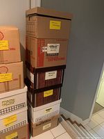 Photo showing five stacked boxes labeled with various categories such as medical, legal, and other books.