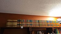 Full shelf view showing multiple cloth-bound volumes on upper shelf.
