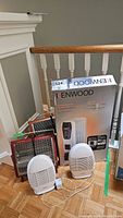 All five items shown together with box behind; Kenwood radiator box visible with two Sunbeam bug zappers and two small heaters in front