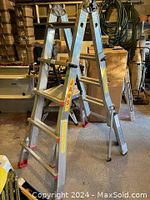 Full view of the Jaws aluminum ladder standing open showing the steps, side rails with branding, and platform area.