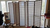 Three shoji screens with dark wooden frames and white translucent panels, displayed side by side near windows.