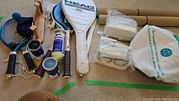 Full view of items including rackets, balls, wooden racket holder, goggles, and bags