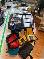 Two yellow Sony Walkman WM-F63 FM/AM cassette players with dials and buttons visible along with soft cases and pouches for carrying. Various cassette tapes and storage boxes in the background.