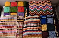 All 5 colorful crochet Afghan blankets shown stacked together, displaying block and stripe patterns in multiple colors