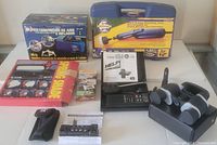 Overview photo showing portable air compressor in box, tire inflator tool kit in blue case, spring shade packaging, and several small hand tools and accessories on a table.