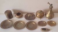 Overview of all ten brass decorative items on display showing variation in shape and size.