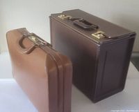 Pair of vintage briefcases side by side, light brown and dark brown, showing exterior and handle details.