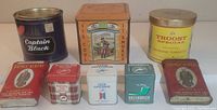 Front view showing all eight tobacco tins with visible brand names and labels.
