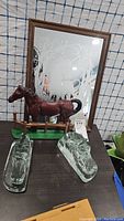 Photo shows the glass bookends, brown horse figurine on green base, and wood-framed mirror with etched deer design placed on a table.