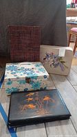 Four assorted storage boxes arranged on floor, showing variety of designs and styles
