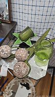 Photo showing ceramic spheres, metal green star-shaped dish, metal green container and decorative scissors.