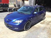 Front passenger side three-quarter view showing blue paint and steel wheel without hubcap