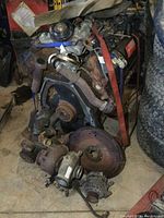 Front view of engine showing timing cover, exhaust manifold, turbocharger, and belt routing.