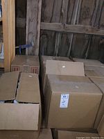 Photo of multiple cardboard boxes containing hand sanitizer bottles with some boxes partially open.
