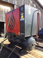 Front three-quarter view showing red/black housing, CP logo, QRS 25 marking and receiver tank mounted on skid.