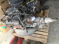 View of 4.6L Lincoln V8 engine and attached automatic transmission on pallet.